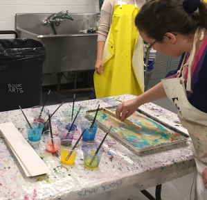 An MTSU student preparing to marble paper in a previous workshop.